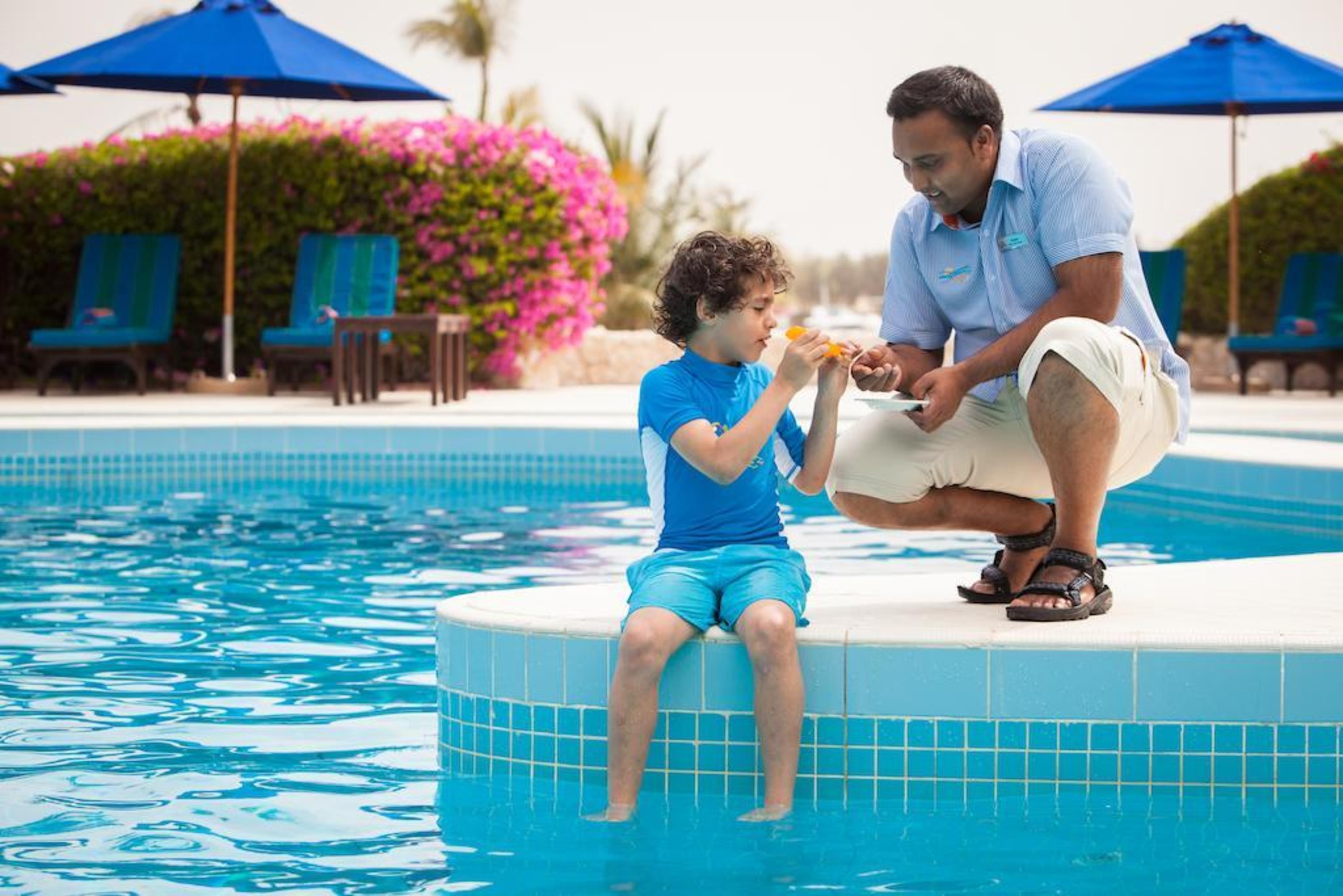 Ja Beach Hotel, Dubai Bagian luar foto A father and son at a pool