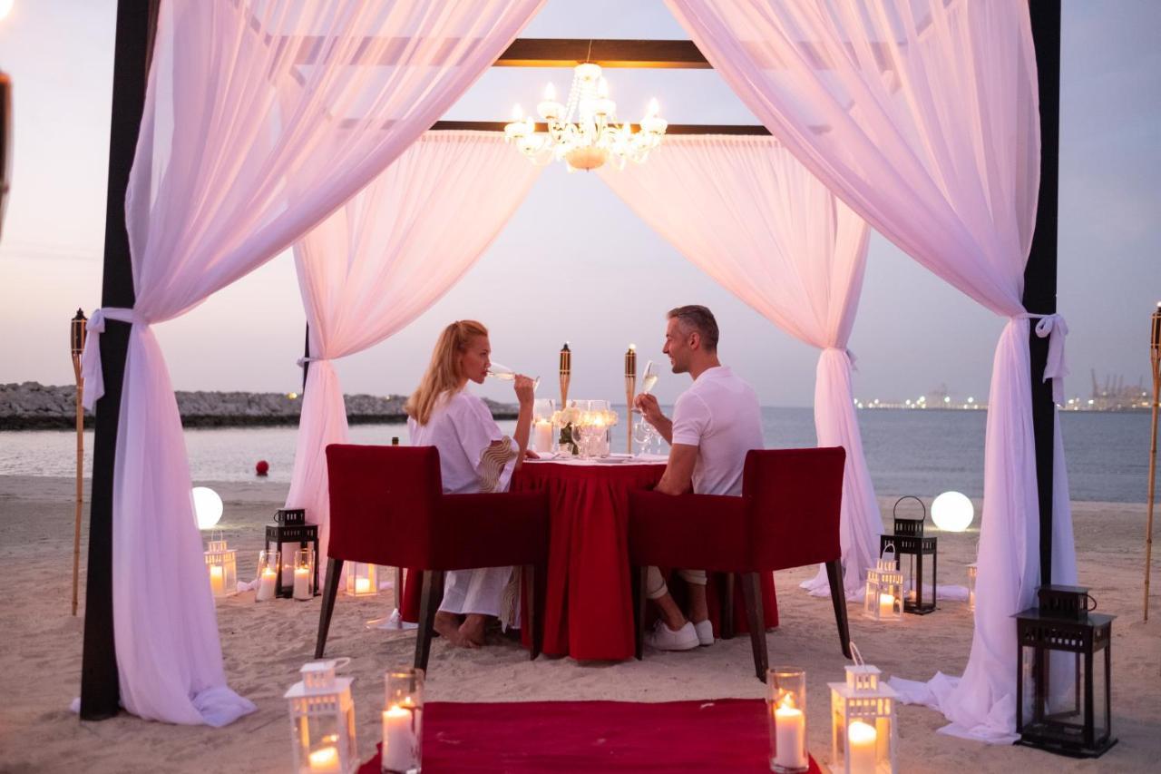 Ja Beach Hotel, Dubai Bagian luar foto A couple dining at a beach resort